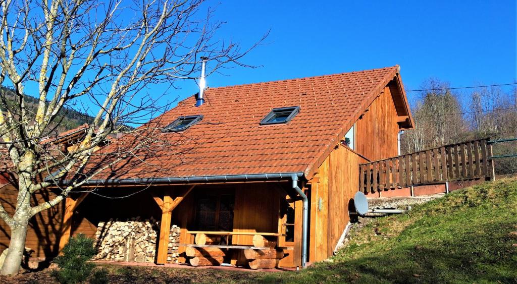 uma casa de madeira com um telhado vermelho em Chalet des Chauproyes em Ventron