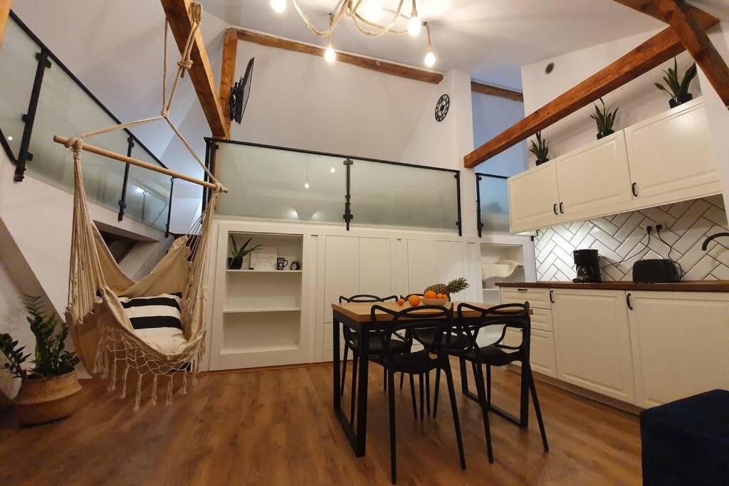 a kitchen with a table and chairs in a room at Koci Dom Loft in Wieliczka