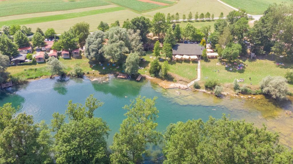 an aerial view of a river with trees and a house at Holiday resort & camping Bela krajina - river Kolpa in Metlika