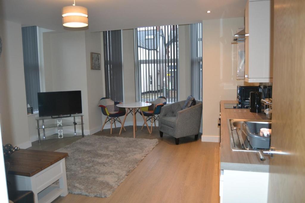 a living room with a couch and a table at Meadow apartments Nottingham in Nottingham