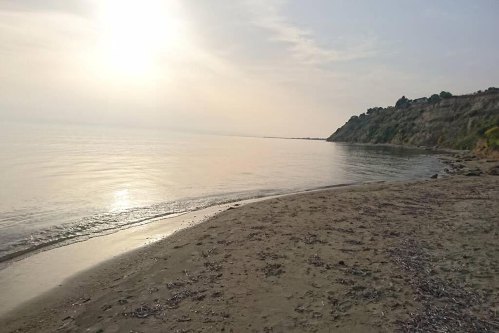 a beach with the sun shining on the water at Sunshine House offering spectacular views to Olymp A in Nea Iraklia