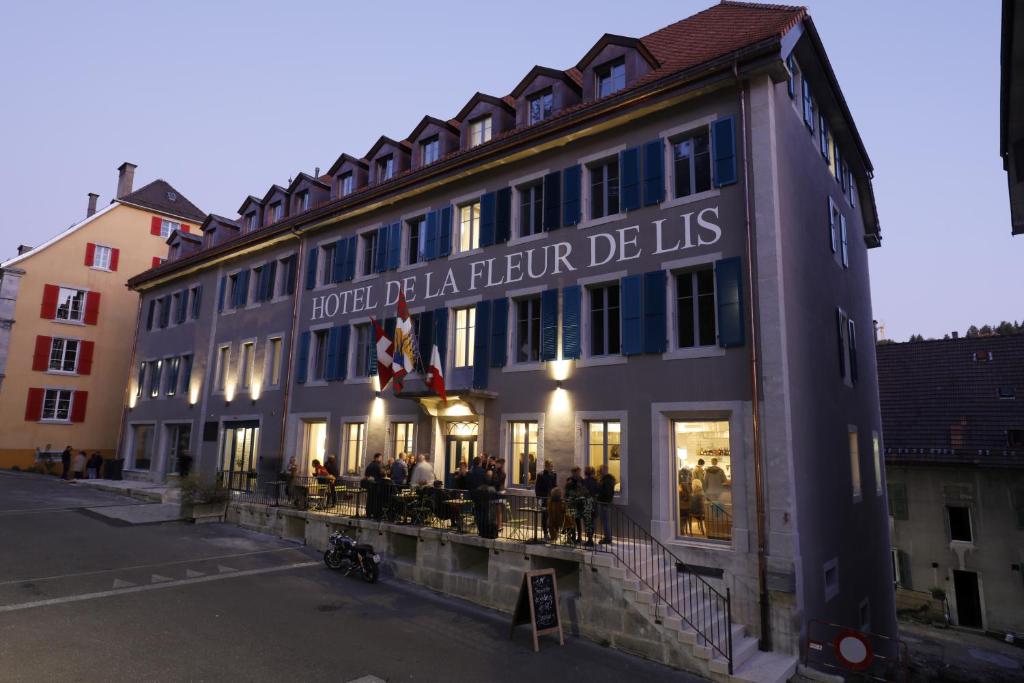 a building with people sitting outside of it at Fleur de Lis in Le Locle
