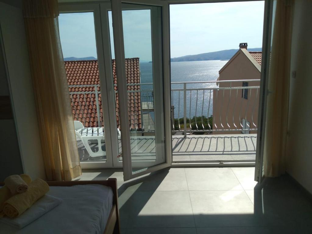 een kamer met een balkon met uitzicht op het water bij Sea side App in Vrataruša