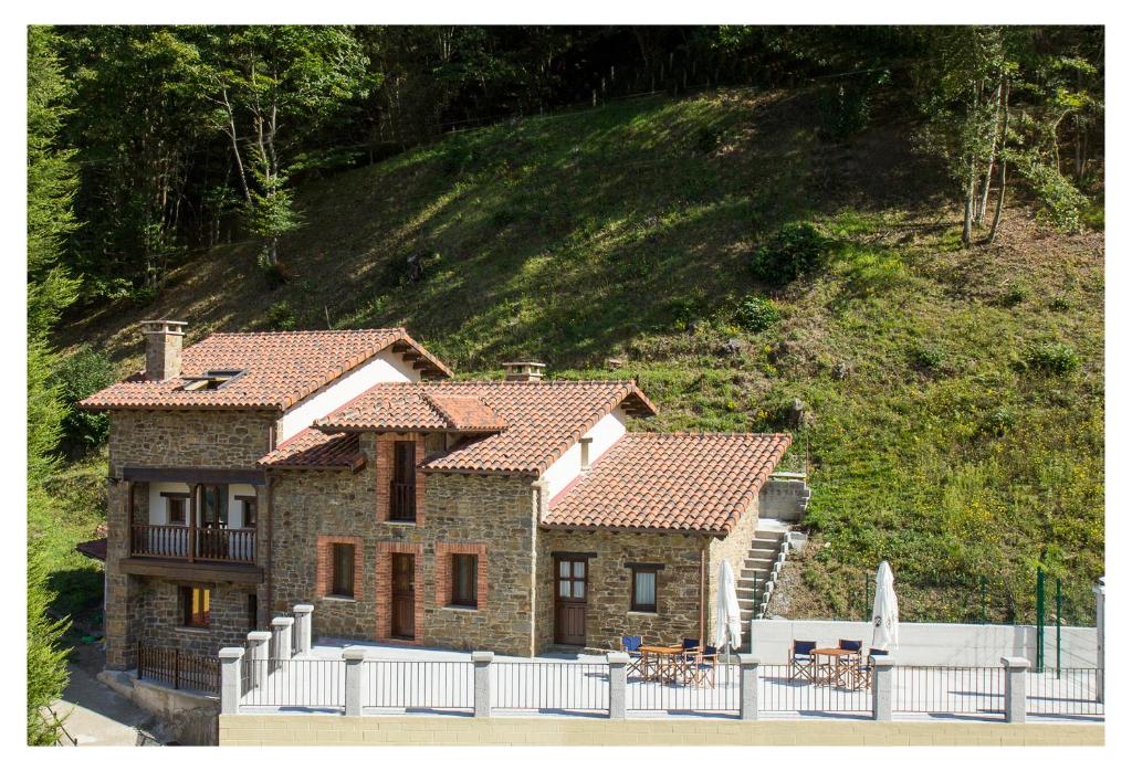 une maison avec une clôture blanche devant elle dans l'établissement Casa Rural Manuel de Pepa Xuaca, à Tuilla