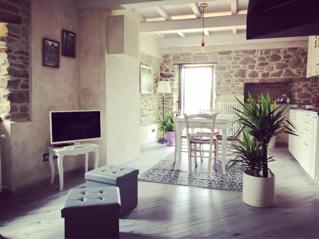 uma sala de estar com uma televisão e uma mesa e cadeiras em Iris Country House em Ortignano Raggiolo