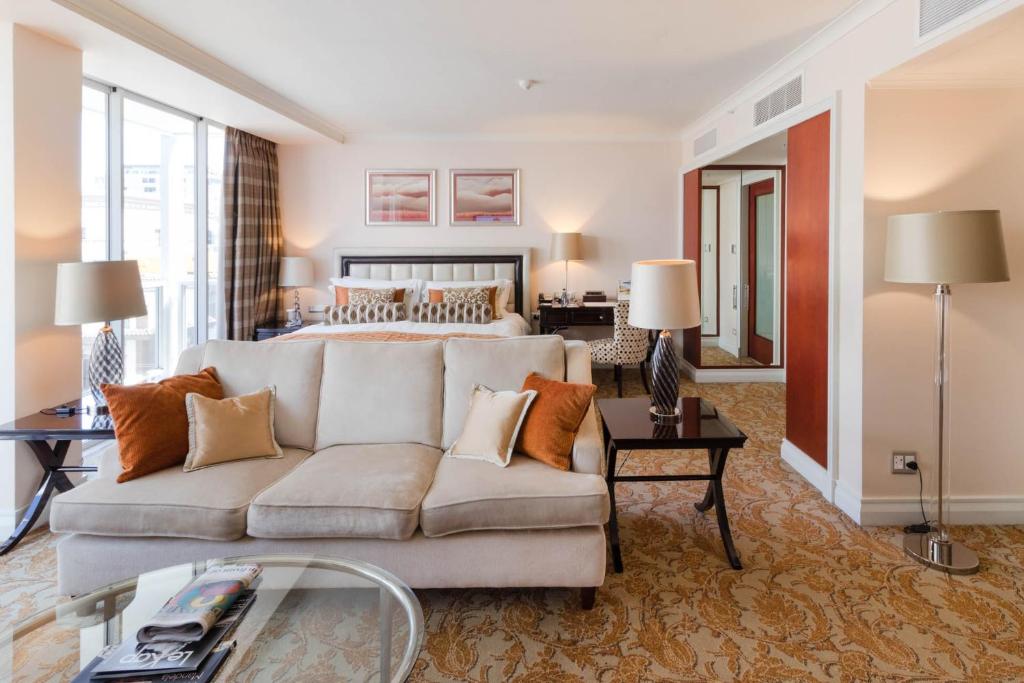 een woonkamer met een bank en een bed bij Taj Hotel Cape Town - Taj Residence suite ,let out privately in Kaapstad