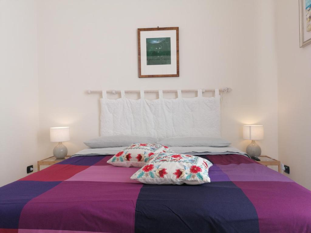 um quarto com uma cama roxa com duas almofadas em B&B Eracle em Ercolano