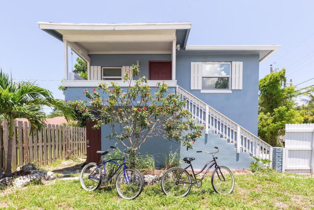 dwa rowery zaparkowane przed niebieskim domem w obiekcie Light and Breezy in SoSo w mieście West Palm Beach