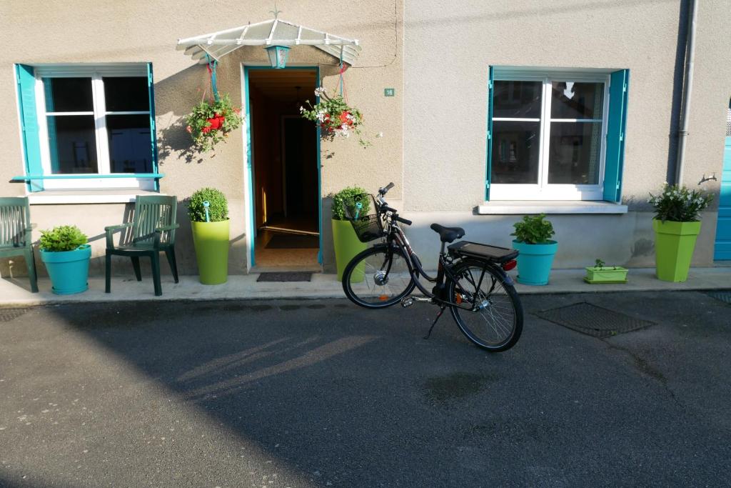 Le Mont des Buis في Le Bourg-dʼHem: دراجة متوقفة أمام مبنى به نباتات