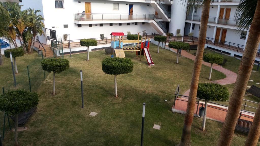 a park with a playground with a slide and trees at Torrox Costa in Torrox Costa