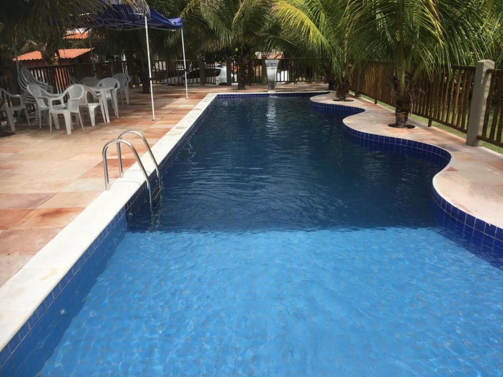 uma piscina com água azul num resort em Pousada Bambui em Ituberá