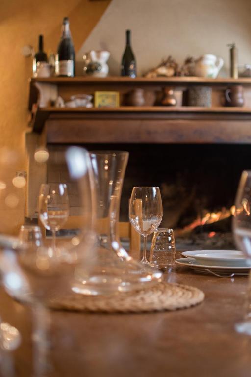 a group of wine glasses sitting on a table in front of a fireplace at Apartments Viler in Buje