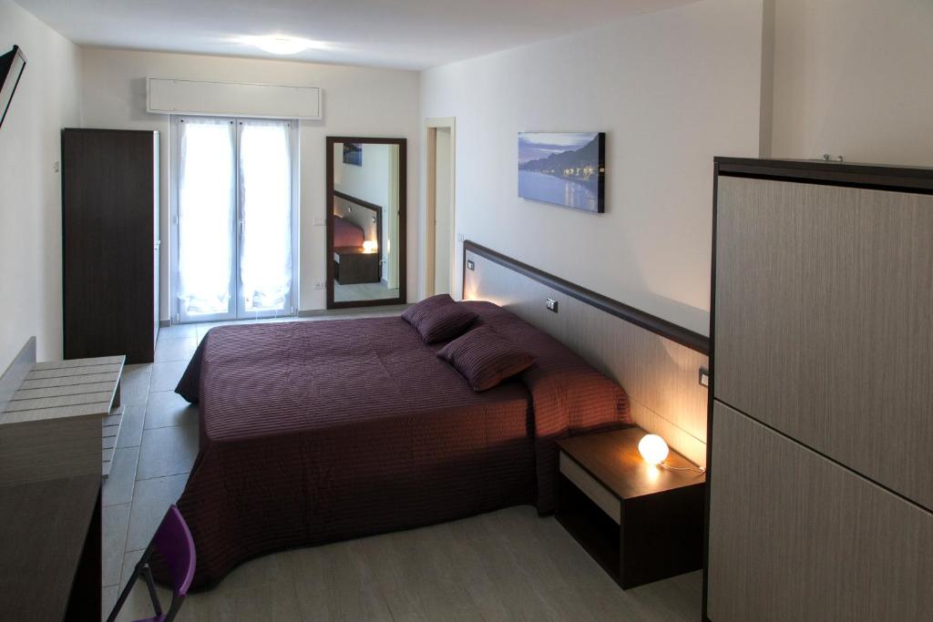 niewielka sypialnia z łóżkiem i oknem w obiekcie Locanda Brezza Marina camera quadrupla w mieście Finale Ligure