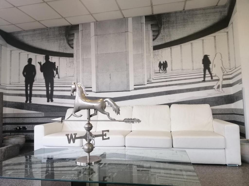 a living room with a white couch and a horse statue at Ahr Hotel Antille in Cazzago di Pianiga