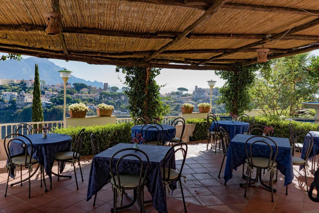 a patio with blue tables and chairs and a view at Ravello View in Scala