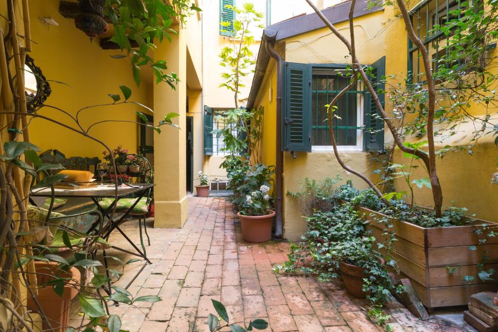 a courtyard with potted plants and a yellow building at B&B AlbertaD in Bologna