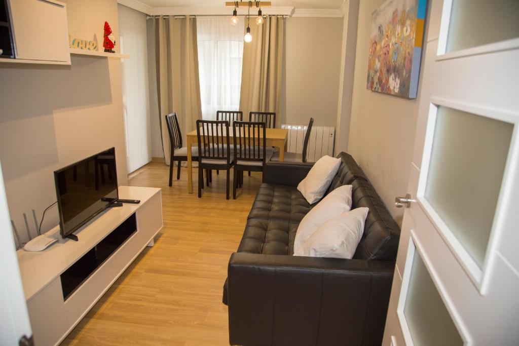 een woonkamer met een bank en een televisie bij Apartamento Reus 2 - Parking gratuito in Reus
