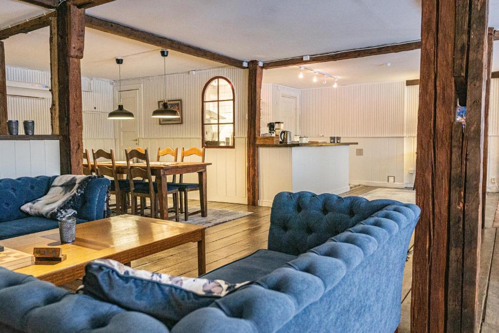uma sala de estar com dois sofás azuis e uma mesa em Ladugårdens Pub & Sal em Enhörna