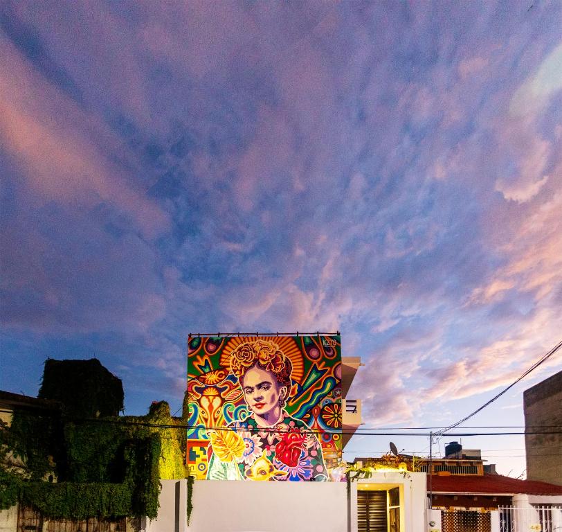 a building with a painting on the side of it at dewl estudios & residences : THE KAHLO in Playa del Carmen