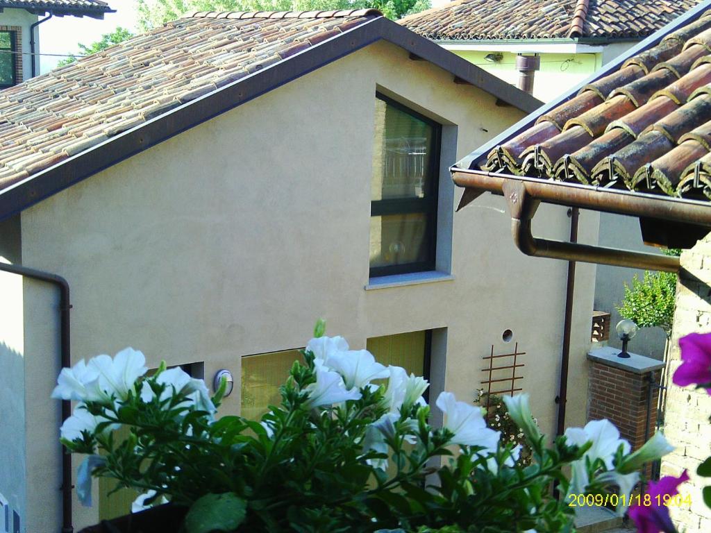 una casa con flores blancas delante de ella en Al Centro del Borgo, en Guarene