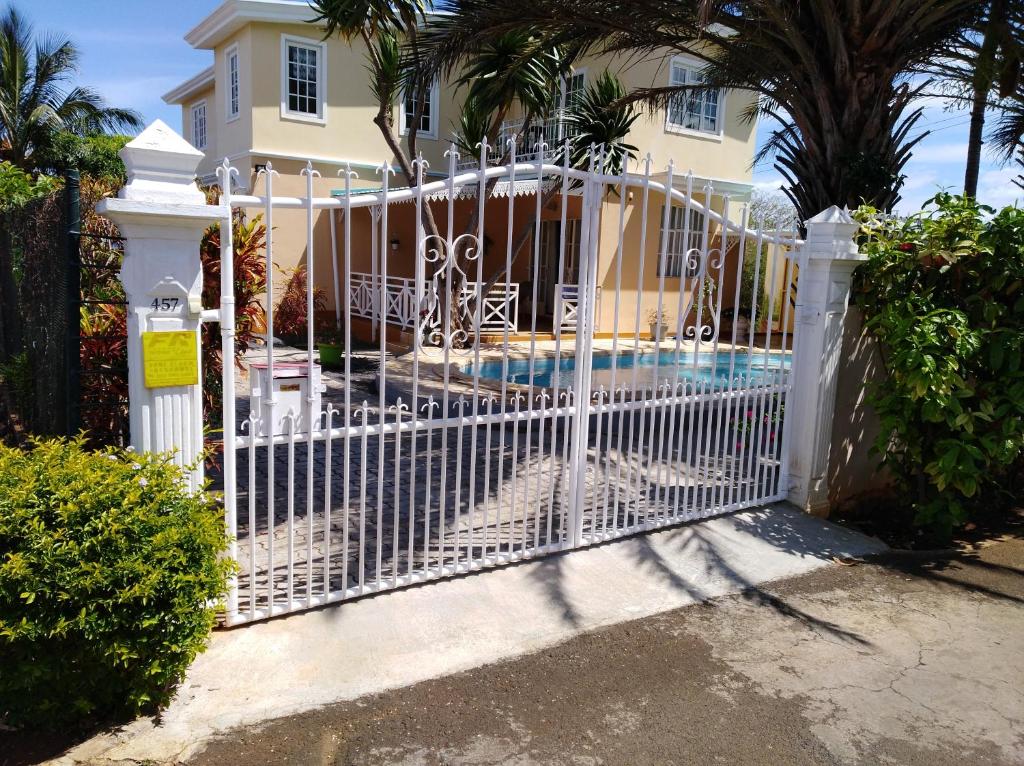 a white gate in front of a house with a pool at Villa kartner in Albion