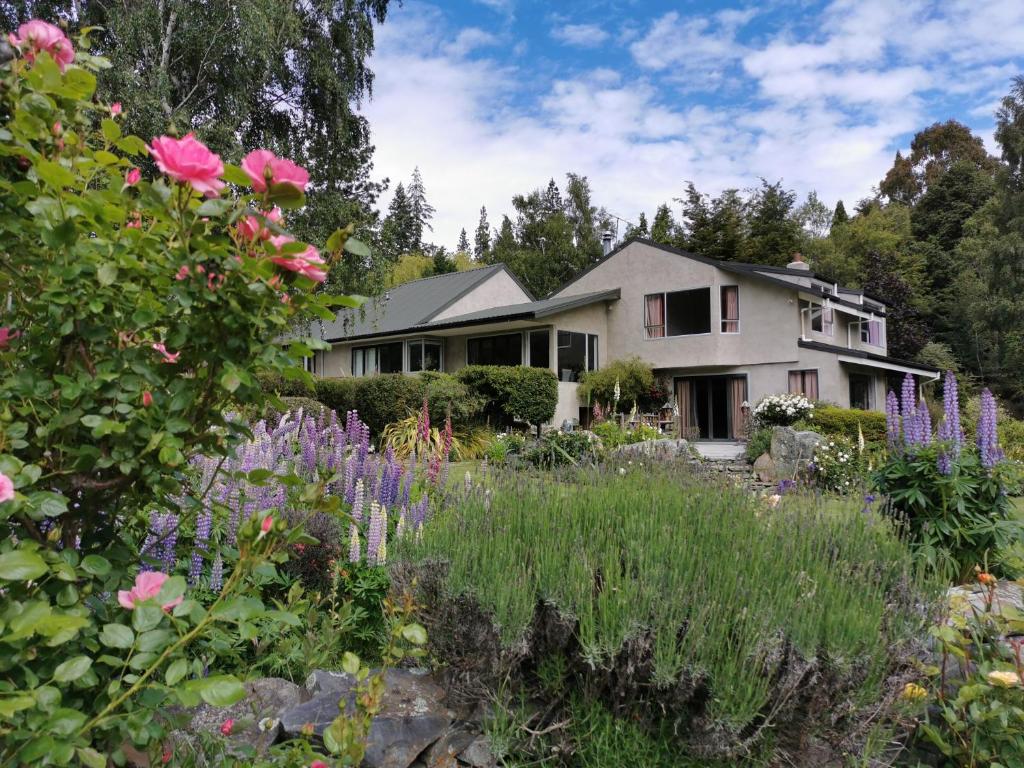 a house with a garden with flowers in front of it at Star Dream Manor in Lake Tekapo