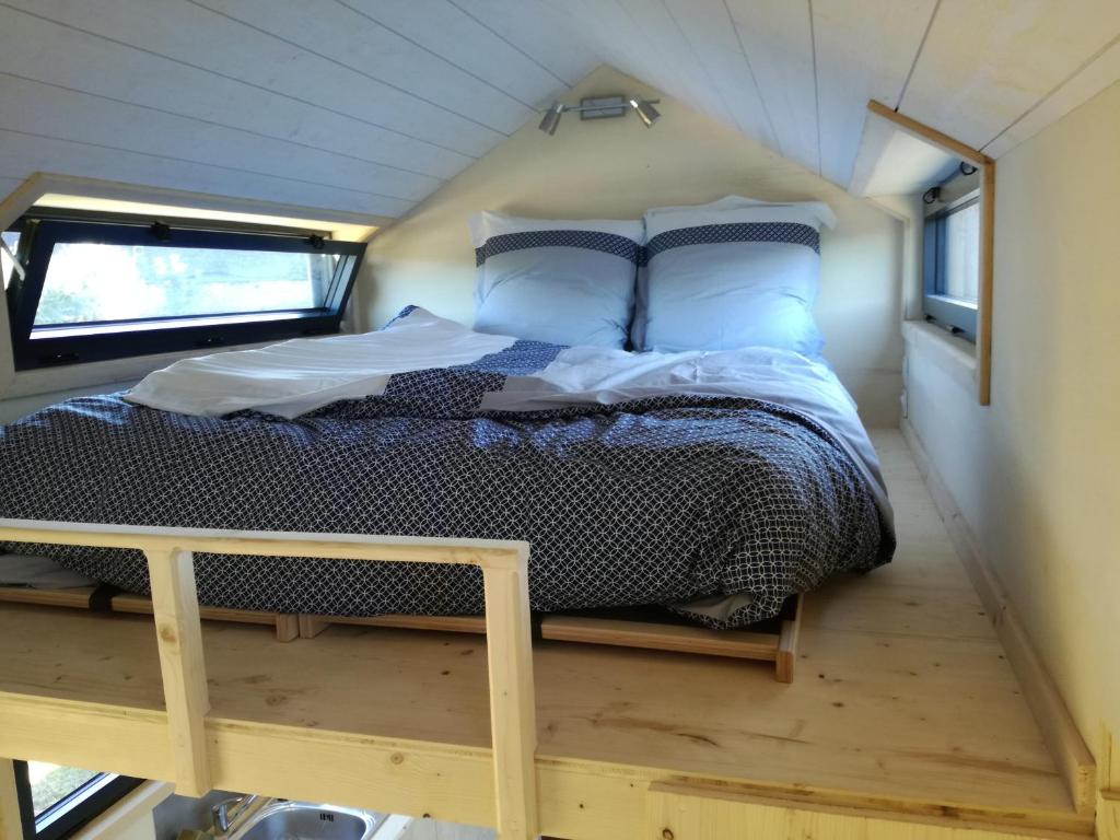 ein Bett in der Mitte eines winzigen Hauses in der Unterkunft Tiny house sur la Presqu'île Sauvage in Lanmodez