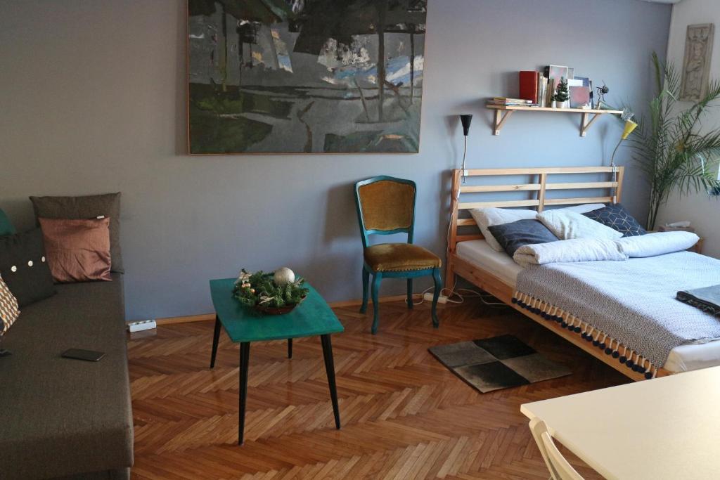 een slaapkamer met een bed, een tafel en een stoel bij Atelier 22 in Belgrado