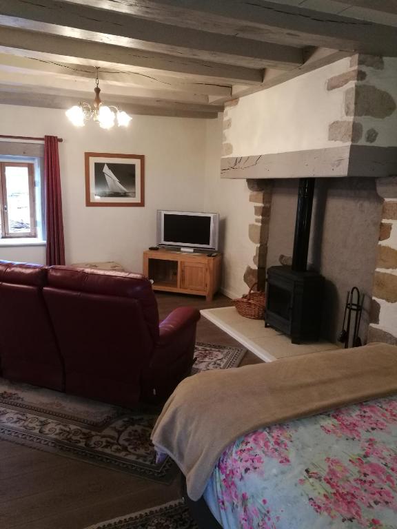 a living room with a bed and a fireplace at Chez Pastuso in Brigueuil-le-Chantre