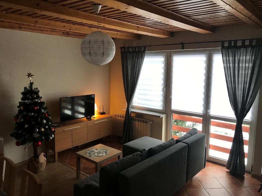 a living room with a christmas tree and a couch at Domek z kominkiem, domek Maja in Międzybrodzie Żywieckie