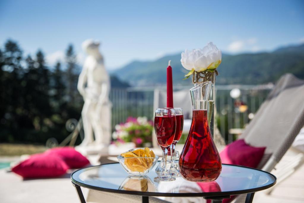 une table avec deux verres à vin et un vase avec une rose dans l'établissement VILLA TURRI - Luxury Country & Padel Resort, à Camporgiano
