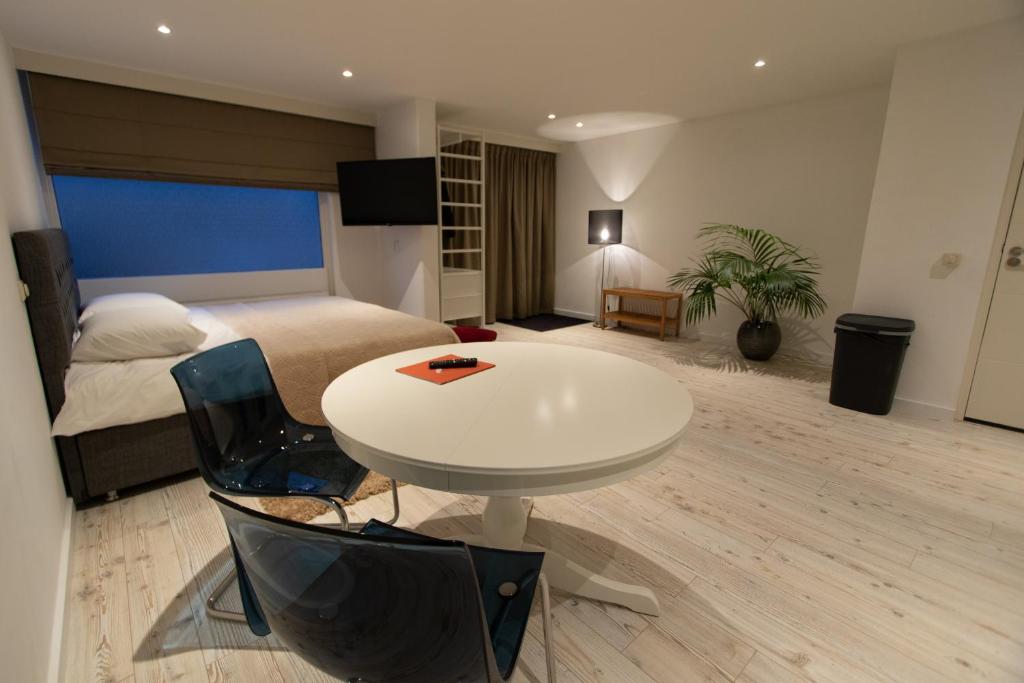 1 dormitorio con 1 cama, mesa blanca y silla en TamTam Studio, en Róterdam