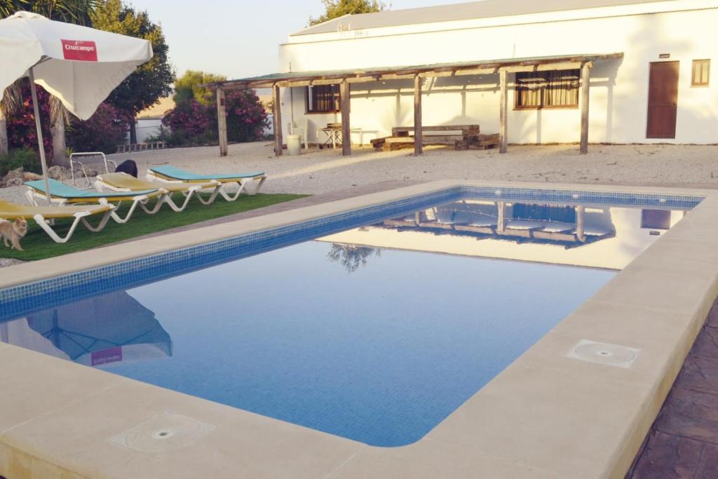 a swimming pool in front of a house at Alojamiento Rural - Finca Santa Margarita in Algar