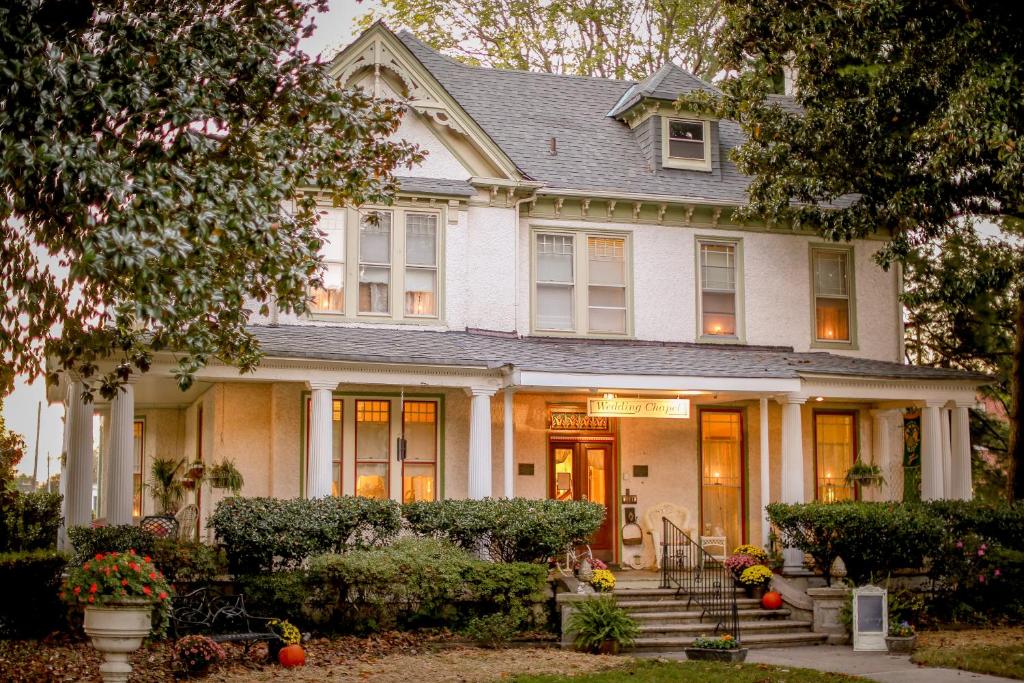 Una casa blanca con calabazas delante. en Magnolia House Inn, en Hampton