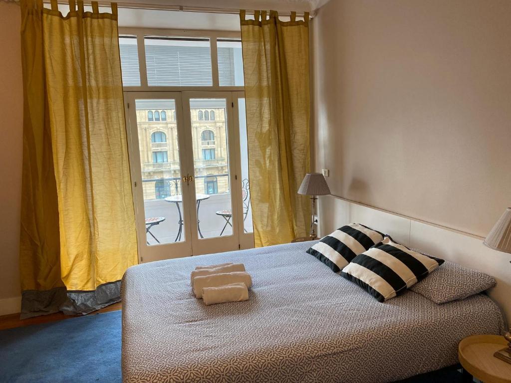 ein Schlafzimmer mit einem Bett mit zwei Kissen und einem Fenster in der Unterkunft Kasa Reina HT LSS00215 in San Sebastián