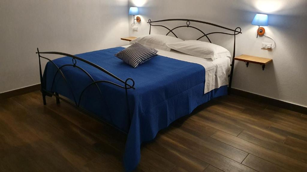 sypialnia z łóżkiem z niebieskim kocem i 2 lampami w obiekcie DOMU NOSTA di Giulio & Ignazia Room1 w mieście Santa Luria