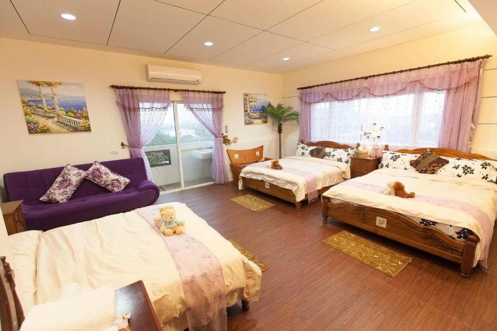 a bedroom with two beds and a purple couch at Winter&#39;s Love in Wujie