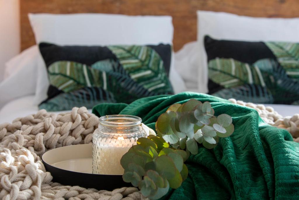 グラナダにあるCasa Flor del Naranjoの緑の毛布を敷いたベッドの上にキャンドル付きテーブル