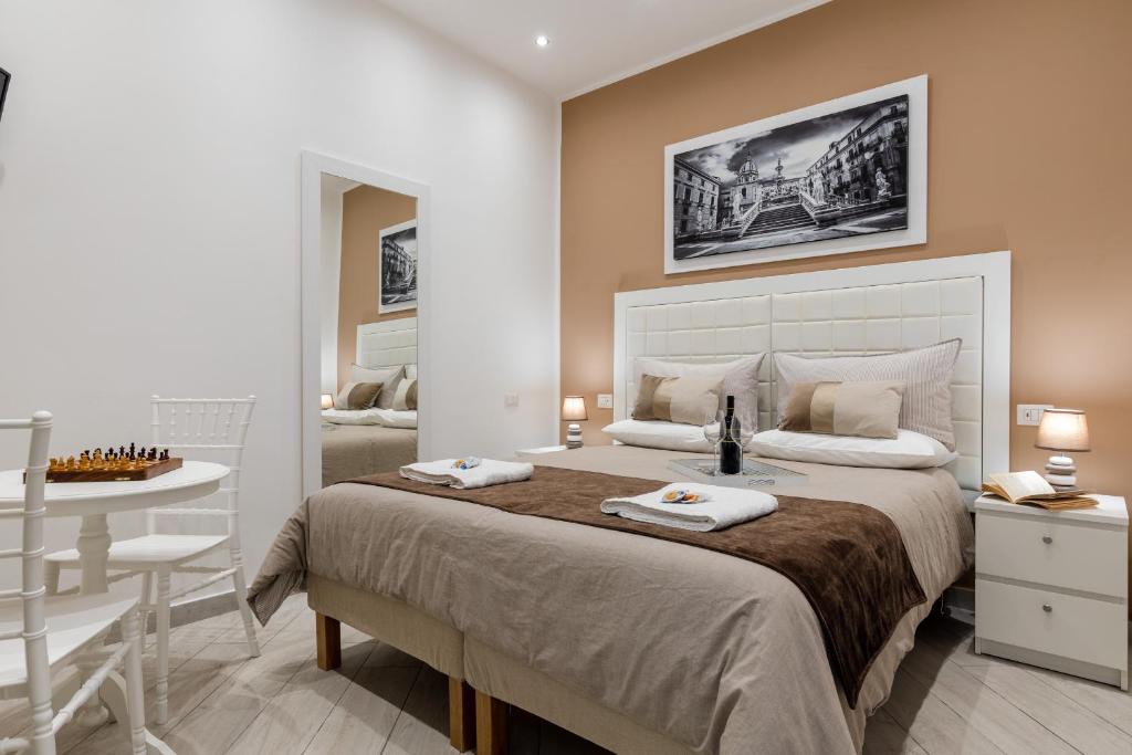 a bedroom with a large bed with a table and a chair at Residenze Chamur Via Volturno in Palermo