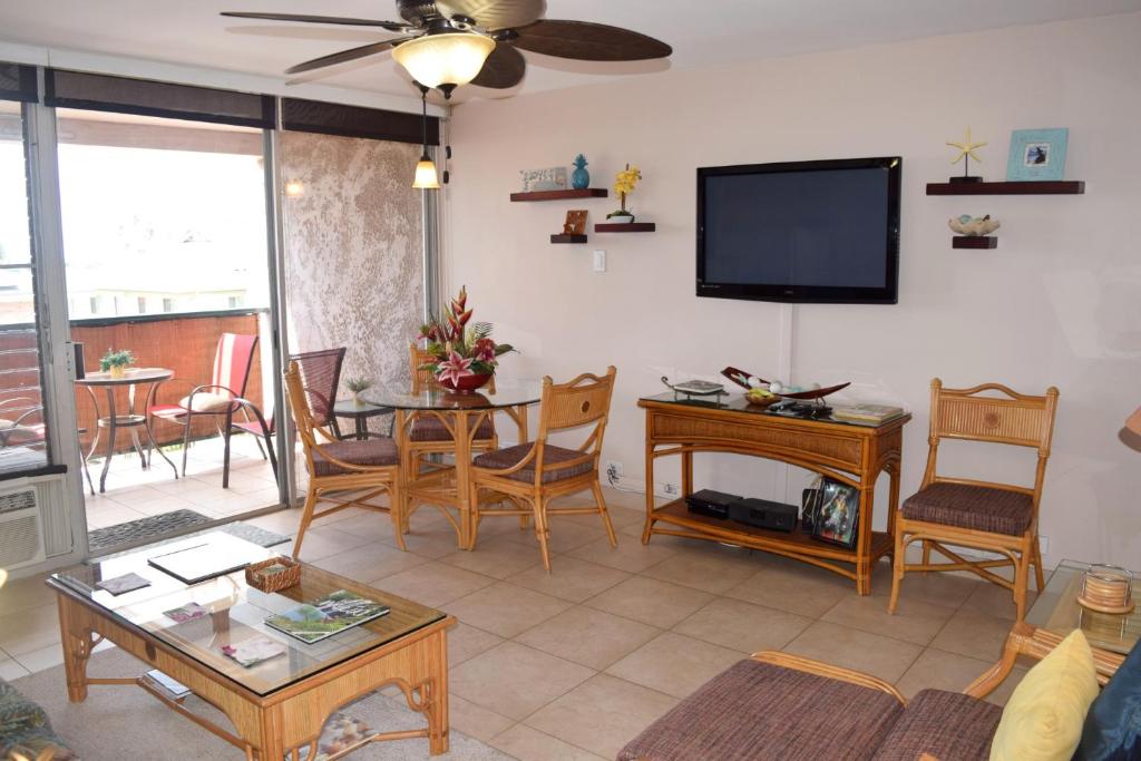 sala de estar con TV, mesa y sillas en Kalama Terrace P309 en Kihei