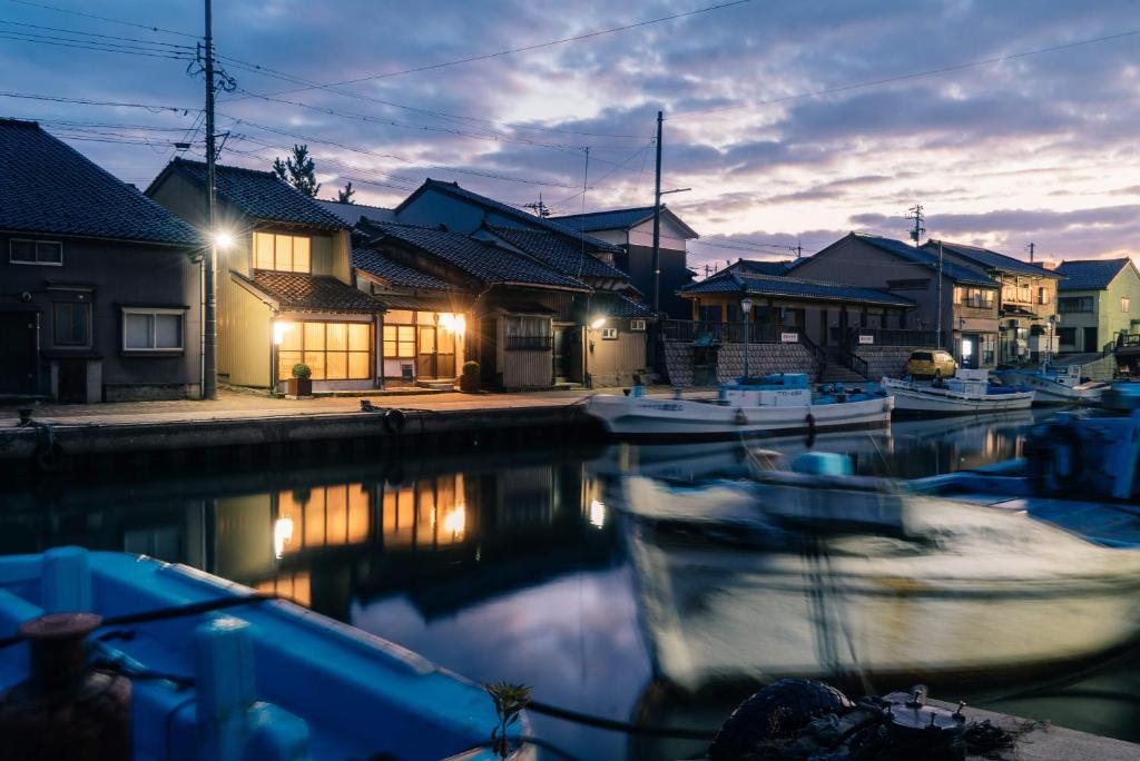 Shimminatoにある水辺の民家ホテル カモメとウミネコの夜間の船の集団