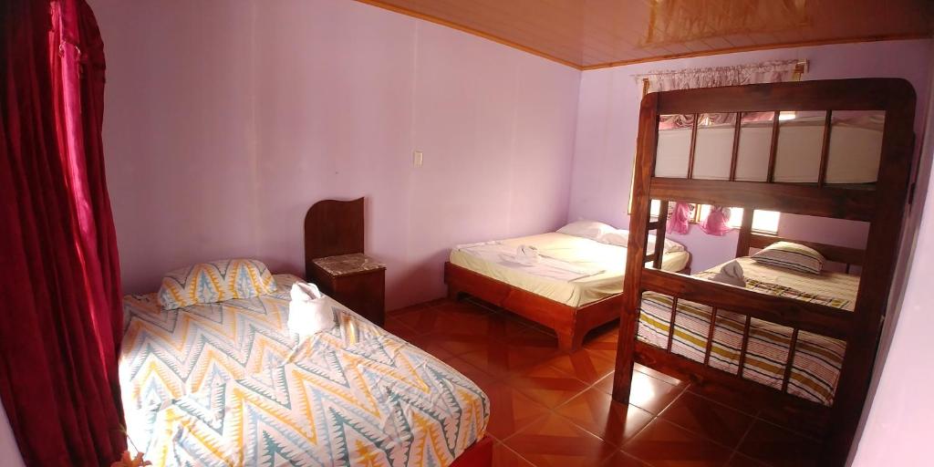 a bedroom with two beds and a bunk bed at Cabinas El Muellecito in Tortuguero