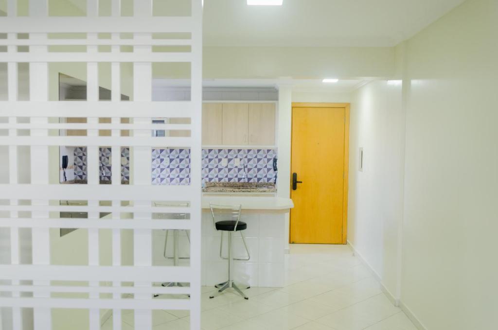 um corredor com uma porta e uma cozinha com um banco em Ótimo apartamento, em excelente localização JL Shopping em Cascavel
