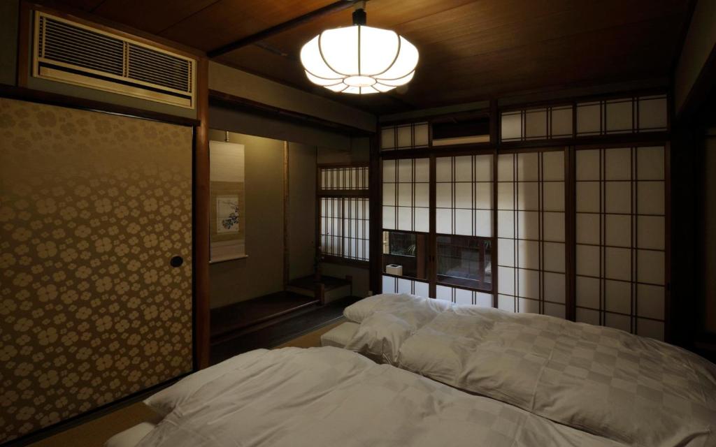 Postel nebo postele na pokoji v ubytování IZUYASU Traditional Kyoto Inn serving Kyoto cuisine