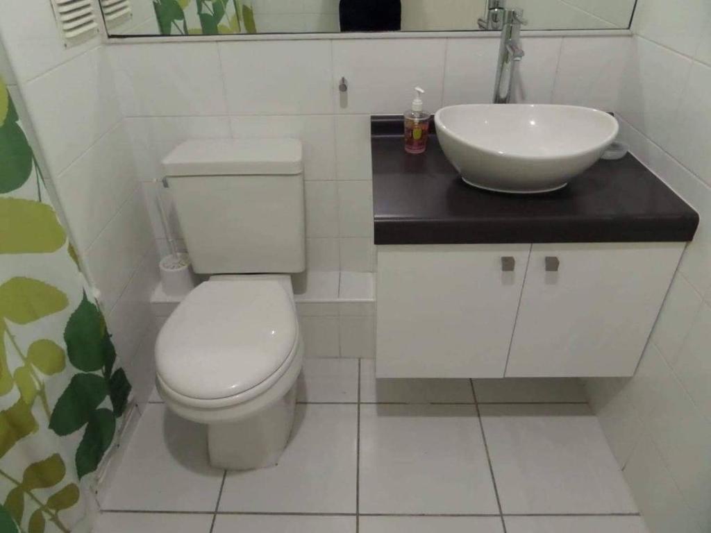 ein Badezimmer mit einem weißen WC und einem Waschbecken in der Unterkunft departamentos La Serena in La Serena