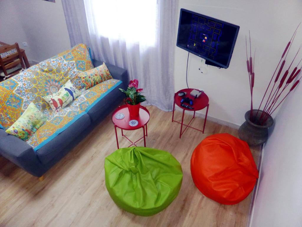 a living room with a couch and two stools at Esencia de Sevilla in Seville