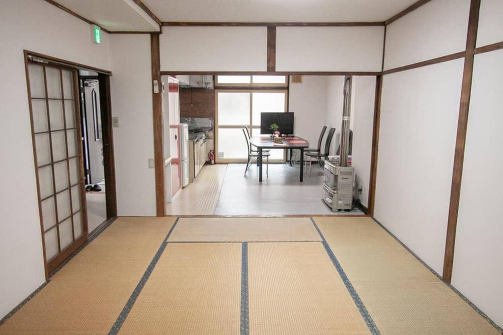 小樽市にある小樽勝納町 古民家のテーブルとダイニングルームが備わる客室です。