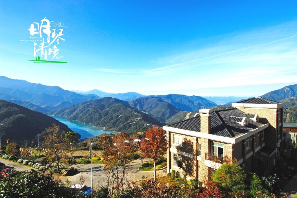 a house with a view of mountains and a lake at Ming Ging Farm in Renai