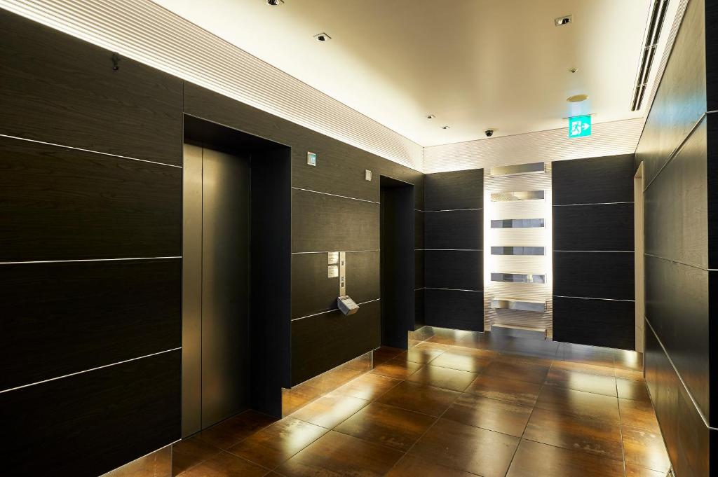 a hallway with black walls and wooden flooring at Sotetsu Fresa Inn Higashi Shinjuku in Tokyo