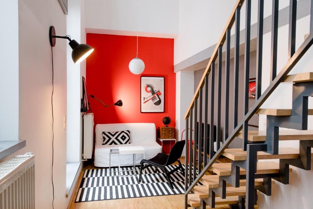 ein Wohnzimmer mit einer Wand mit roten Akzenten und einer weißen Couch in der Unterkunft LE-Style! Top-Galerie-Studio Bauhaus-Stil in Leipzig